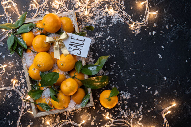 符号木箱里的橘子照片 带花环的黑桌子上的明信片圣诞节年篮子