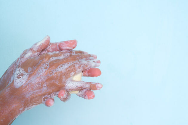 护理用蓝色背景的肥皂洗手手指手清洁