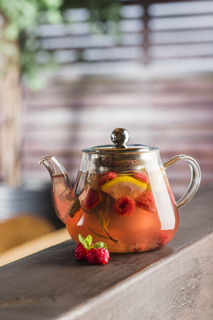 茶一个有浆果茶和一片柠檬和薄荷的茶壶饮料玻璃玻璃茶壶