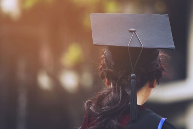 光毕业典礼期间的毕业帽拍摄成功大学毕业生 概念教育祝贺你毕业在毕业典礼上 向大学毕业生表示祝贺证书投掷未来