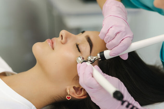 机器柔美女性面部特写皮肤女人在美容诊所做美容手术皮肤护理激光真空