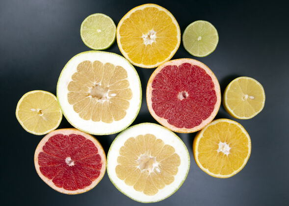 甜点在深色的背景上切块不同的柑橘类水果柠檬甜味圆形