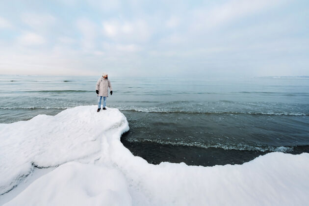 自然年 一位游客站在波罗的海岸边冬天冬天波罗的海诸国附近塔林旅行家冬天在海边风秋天扩张