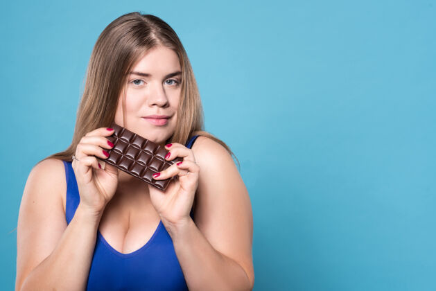 控股甜蜜但是垃圾关闭-可爱的胖乎乎的女士拿着巧克力的画像漂亮女性女性