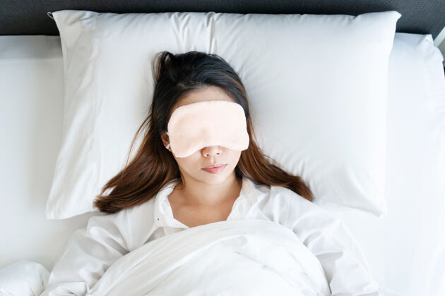 亚洲人亚洲妇女戴着睡眠面罩在床上睡觉的俯视图休息房子房间