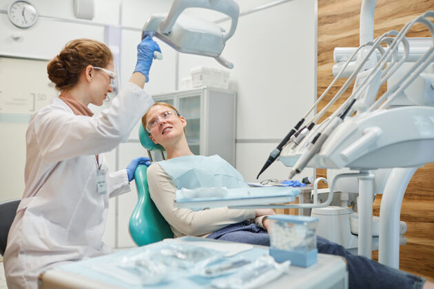 医疗职业病人躺在牙科椅上 在诊所体检时和牙医交谈医疗程序护士药品