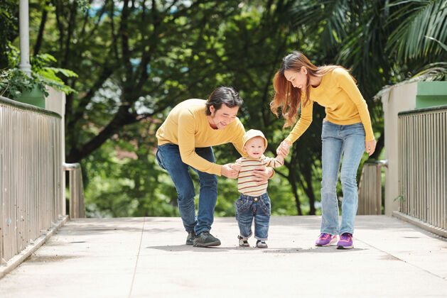 白天父母和小男婴一起在公园散步休闲服妈妈爱