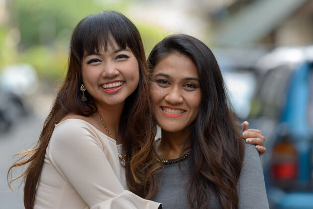 同性恋两位年轻的亚洲女商人在城市户外的合影街道女士泰国