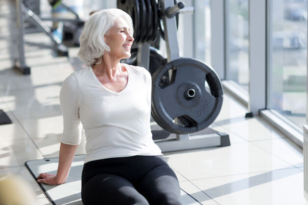 能量愉快的放松快乐在健身房锻炼后微笑放松的运动型高级女性身体年龄女人