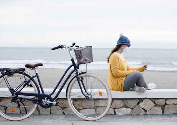 休闲一位数字营销人员坐在海边散步时 正在做一个新的笔记本电脑促销项目自行车独立女性与客户沟通女孩娱乐女性