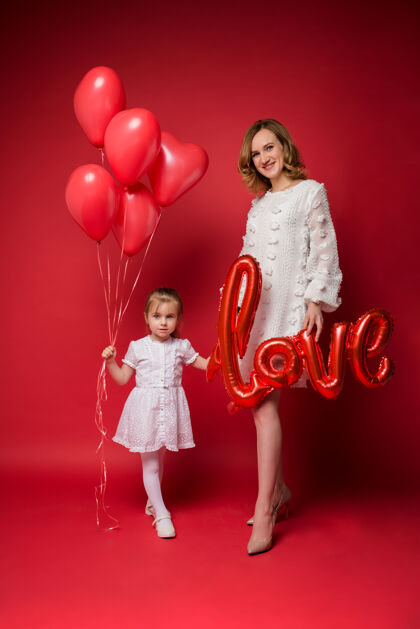 雪纺带着气球爱心的妈妈抱着满满一抱的红气球站在红地毯上父母节日女儿