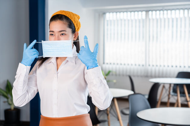 人漂亮的亚洲女服务员戴口罩以防流行性病毒爆发亚洲人面具工作