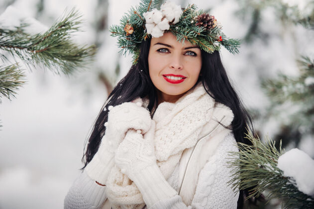 圣诞寒冬白衣女子画像森林女孩她头上戴着花圈在冰雪覆盖的冬季森林里人户外微笑