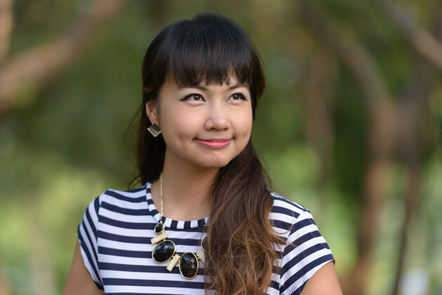 自然年轻美丽的亚洲女子在公园户外放松的写真发型沉思东南