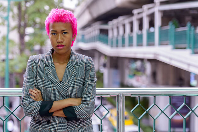 女性年轻叛逆的亚洲女商人的肖像 粉红色的头发在城市户外的人行天桥上亚洲人短裤朋克