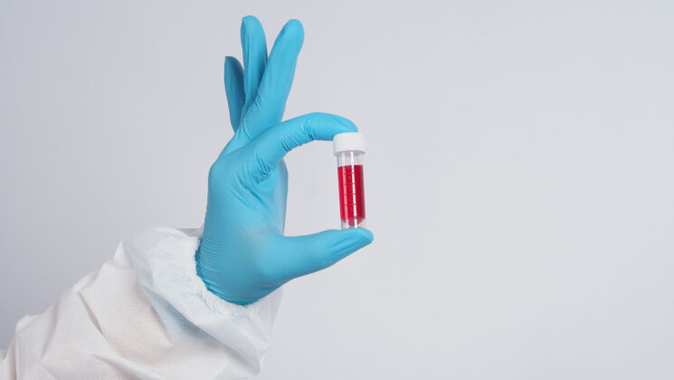 测试血圆管19测试医生手拿血样管在实验室进行分析技术员戴着医用手套拿着血样管进行研究血液测试工作冠状病毒