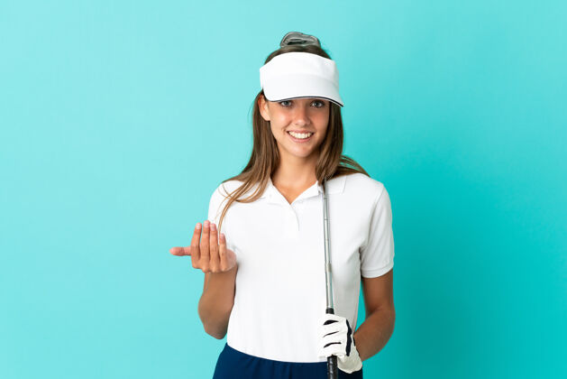 高尔夫一位年轻女子在蓝色背景下打高尔夫球 做着即将到来的手势锦标赛漂亮运动