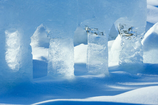 柱雪地上透明的冰柱被春天的阳光照亮了冷水晶冰川