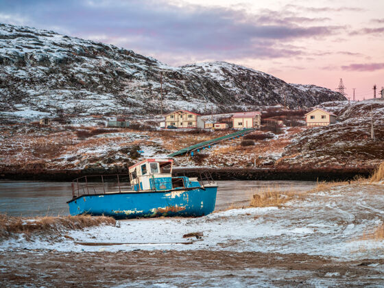 心情一艘生锈的旧渔船被暴风雨遗弃在海边海岸墓地船 巴伦支海岸边的老渔村 科拉半岛 特里伯克 俄罗斯船北极风暴
