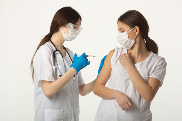 医院一个穿着白色背景的医疗服 拿着疫苗和注射器的女人在接种疫苗流行病疫苗诊所