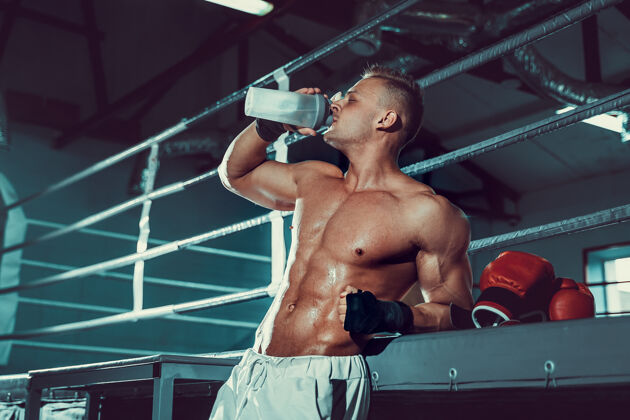 喝酒肌肉发达的白种人 在拳击运动后休息 在健身房喝摇床里的水运动补充比赛
