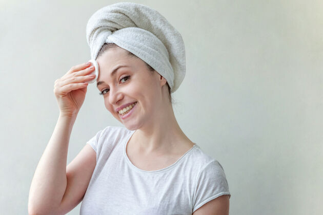 垫头上戴着毛巾的微笑女人的美丽肖像 柔软健康的皮肤 用隔离在白色背景上的化妆棉卸妆水疗毛孔皮肤护理