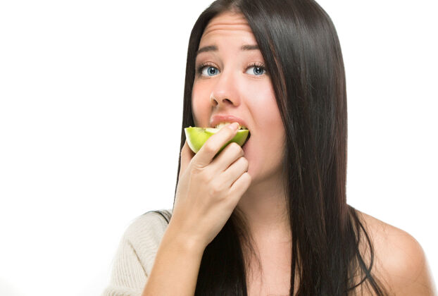 女孩一个女人试图咬一个新鲜的青苹果 她被隔离在白苹果上脸人营养