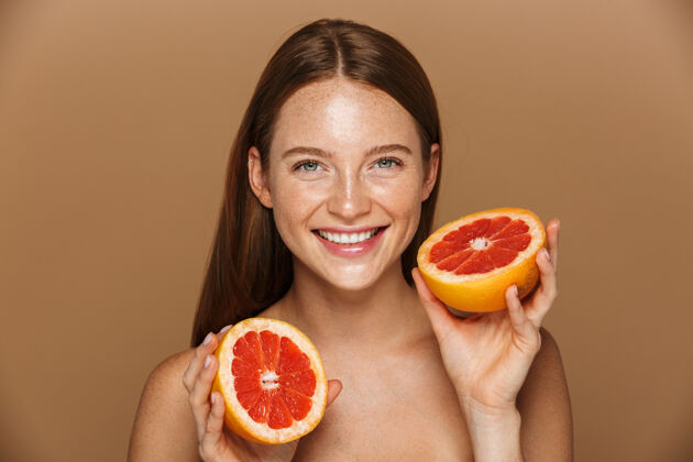 自然美丽的肖像 一个美丽健康的年轻裸体女子长着红色的头发显示切片柚子隔离在米色墙上女人身体搞笑