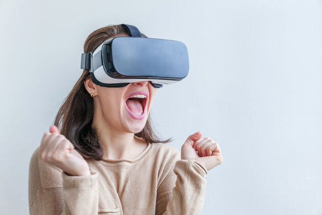 视频游戏微笑的年轻女子戴着虚拟现实vr眼镜头盔耳机在白色背景上护目镜使用惊人