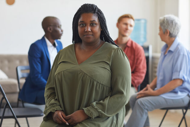 心理医生年轻的非洲裔美国妇女的肖像 在支持小组会议期间 人们坐在一圈的表面 复制空间年轻人意识团队合作