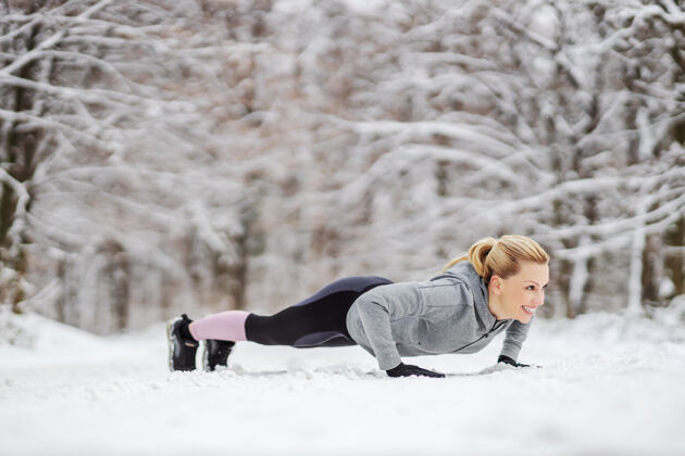 决心在雪地上做俯卧撑的女运动员冬天冬天健身 下雪天气 健活跑步强壮慢跑