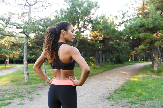 身体苗条的非洲裔美国妇女20多岁 穿着黑色运动服 在绿色公园锻炼身体健身运动女性