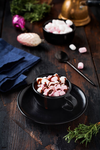 圣诞节热巧克力和棉花糖糖果在旧的黑色复古木制表面上的黑色陶瓷杯酒吧自制的庆祝