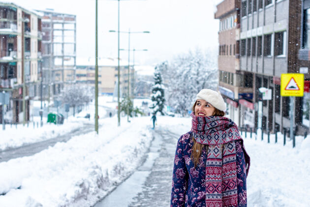 路灯一个年轻的金发女人穿着冬装在城市的雪地大道上的肖像场景大街服装