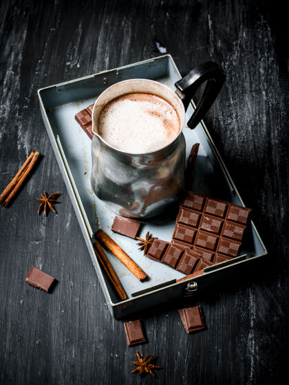 桌子热巧克力加肉桂和苦巧克力放在黑色乡村餐桌上奶油可可咖啡馆