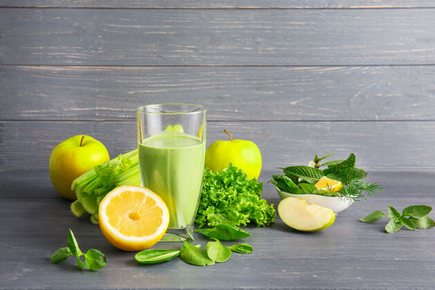 莴苣一杯绿色健康的果汁和水果蔬菜放在木桌上混合能量食谱