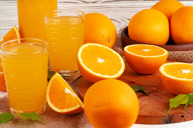 切片一杯橙汁和切好的橙子放在桌上挤压多汁果汁