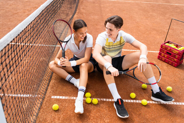 情侣一对夫妇坐在网球场上女人运动球场