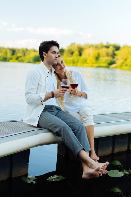 河流我们的未来一对幸福的夫妇一边在河边喝酒 一边憧憬着自己的未来玻璃休息情侣