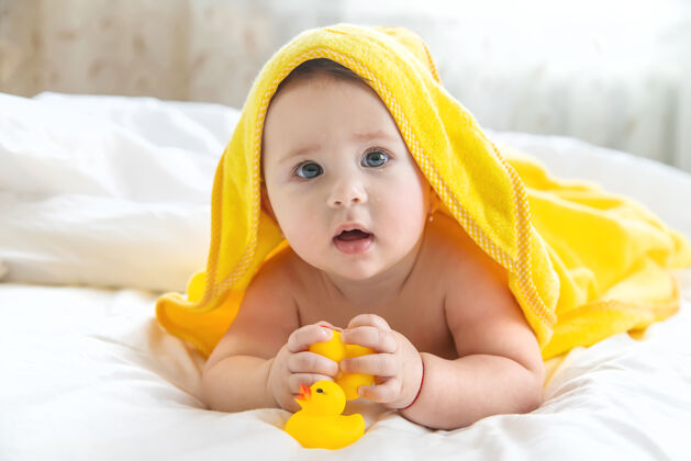 可爱宝宝用毛巾洗澡后肖像玩皮肤