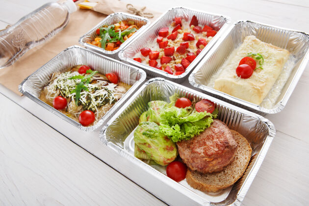 卷心菜卷健康的餐厅食品在铝箔盒中提供绿色炖卷心菜卷配小牛肉牛排 黑面包和其他菜肴牛肉和蔬菜配樱桃番茄外卖特写镜头烤盒子健康