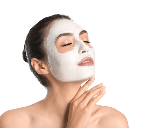 护理美丽的年轻女子 脸上戴着白色的面具面部沙龙治疗