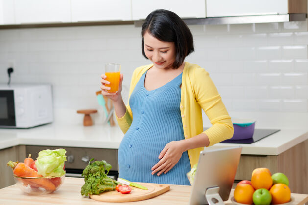 中国人孕妇在厨房喝健康果汁站立肖像产妇