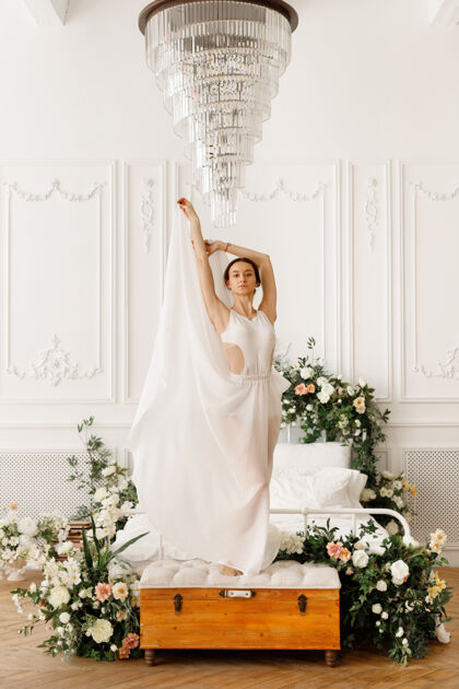 优雅在水晶吊灯旁穿着白色裙子的舞者白色女人房子