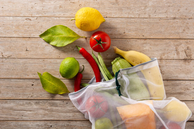 香蕉环保的可重复使用的购物袋与蔬菜和水果在木桌上木材食品生态