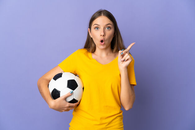 女人立陶宛年轻的足球运动员 一个被隔离在紫色背景下的女人 一边举起手指 一边想实现解决方案女性怀疑微笑