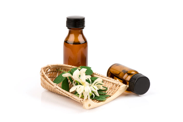 皮肤护理辣木花 绿叶和提取的瓶子隔离在白色治疗生的药物
