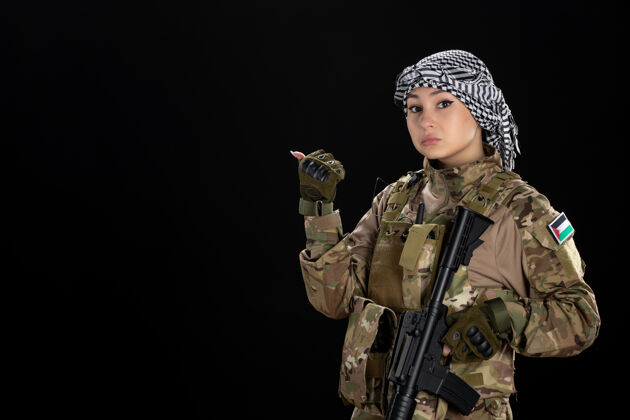 女兵穿军装的女兵拿着步枪站在黑墙上人武器女人