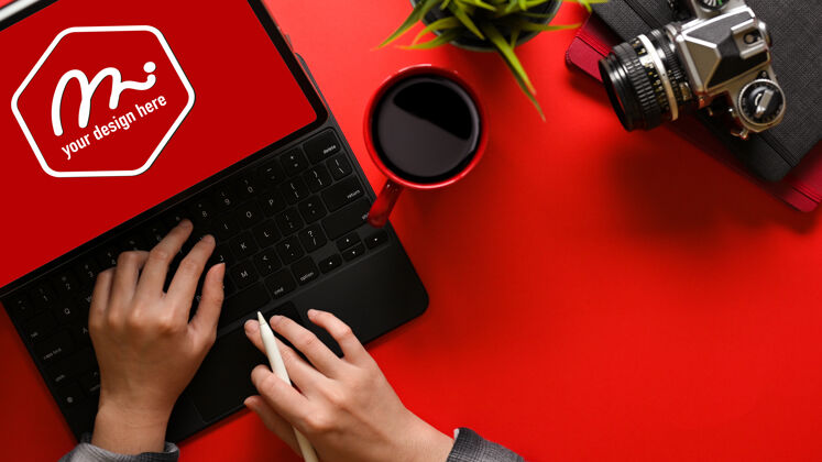 键盘年轻女子在亮红色桌面上的模拟平板电脑上打字的俯视图 复印空间包括剪辑路径实体模型桌面相机