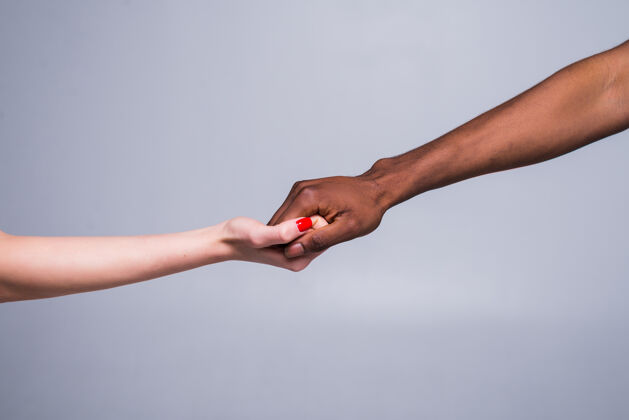 女人白人女性的手和黑人男性的手握在一起护理手人